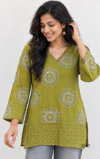 Olive green cotton short top with circular white and dark print and tonal cutwork-style lower panel.