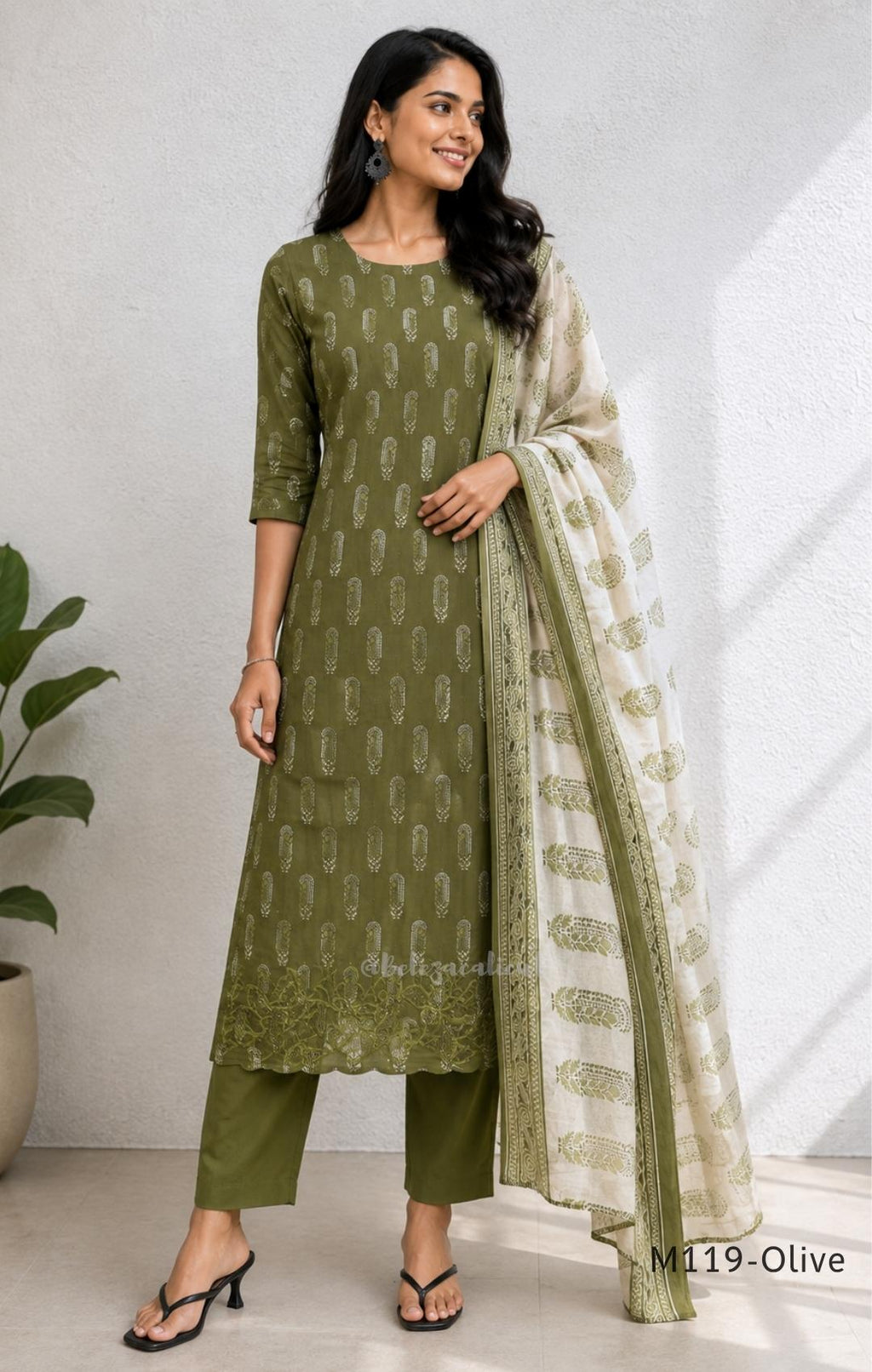 Olive green Cotton Silk churidar set with printed motifs, embroidered floral hem and cream-and-olive printed dupatta.
