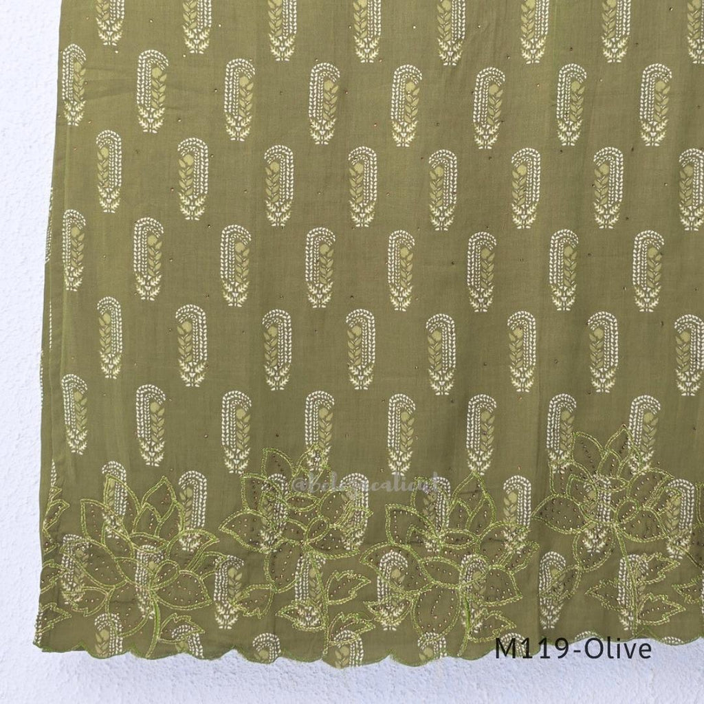 Olive green Cotton Silk churidar set with printed motifs, embroidered floral hem and cream-and-olive printed dupatta.