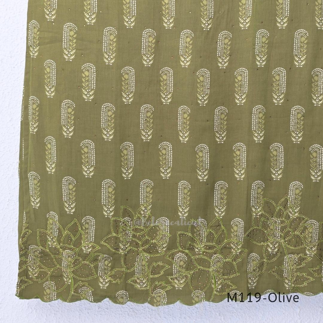 Olive green Cotton Silk churidar set with printed motifs, embroidered floral hem and cream-and-olive printed dupatta.