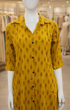 Yellow patterned dress on a mannequin in a store setting