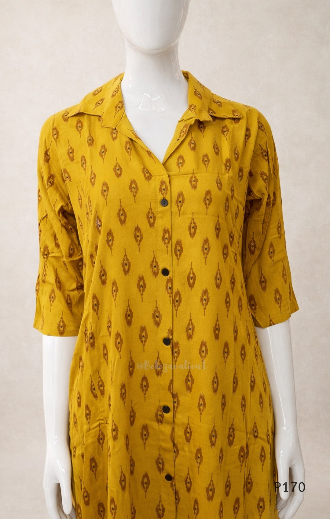 Yellow patterned shirt on a mannequin against a plain background
