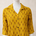 Yellow patterned shirt on a mannequin against a white background