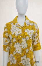 Yellow floral shirt on a mannequin against a white background
