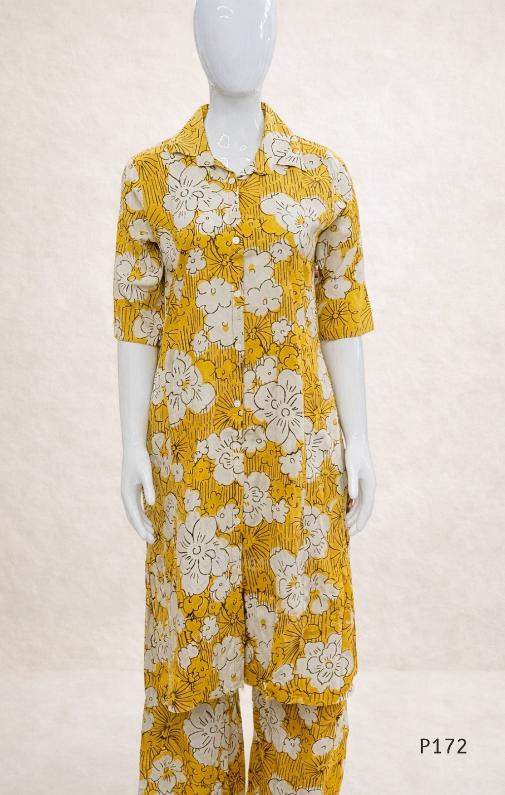 Mannequin wearing a yellow floral dress with a plain background