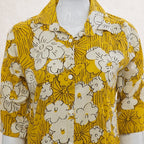Yellow floral patterned shirt on a mannequin against a white background