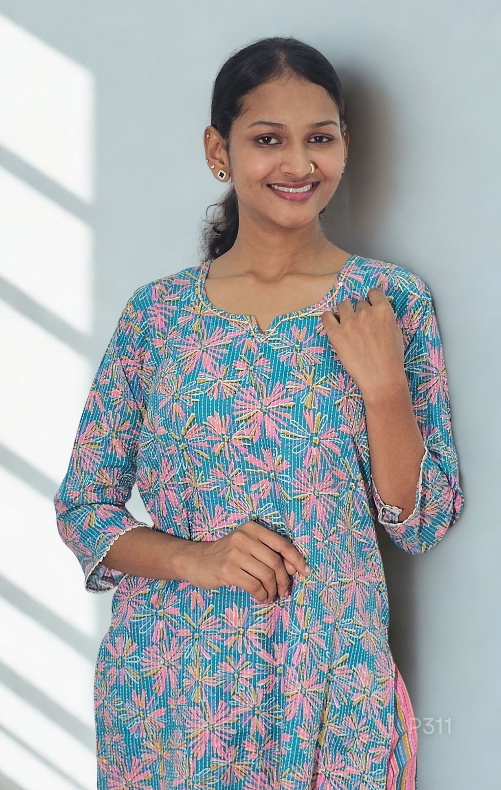 Woman wearing a colorful floral dress against a light background