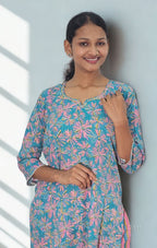 Woman wearing a colorful floral dress against a light background