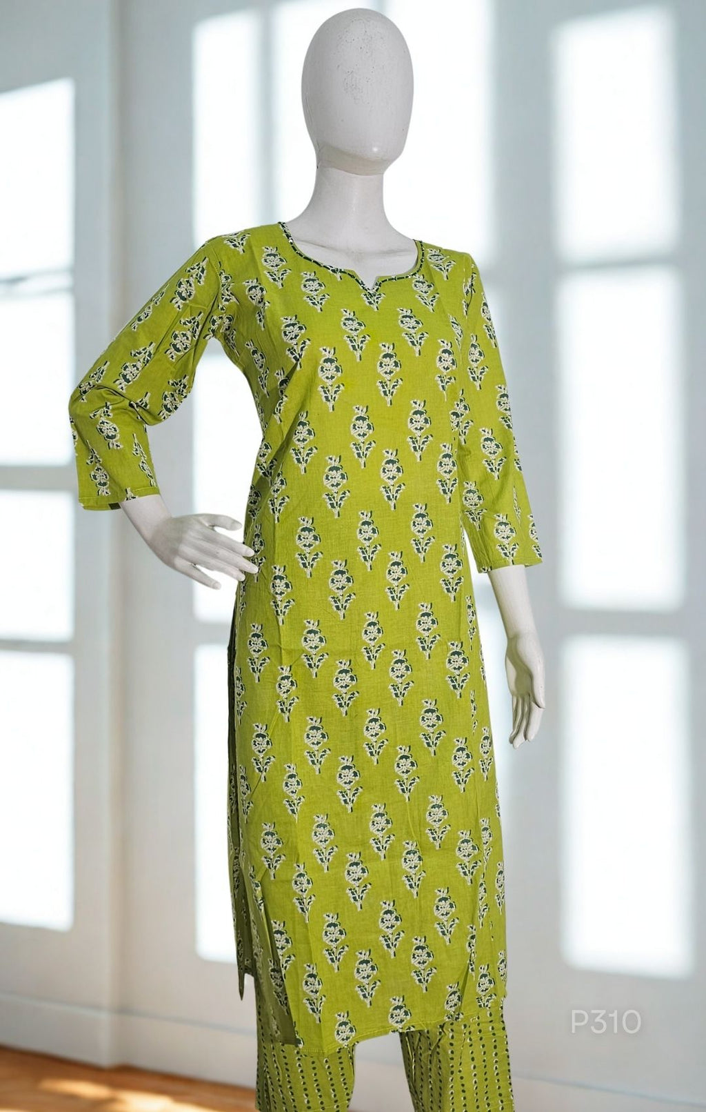 Green patterned dress on a mannequin against a white background