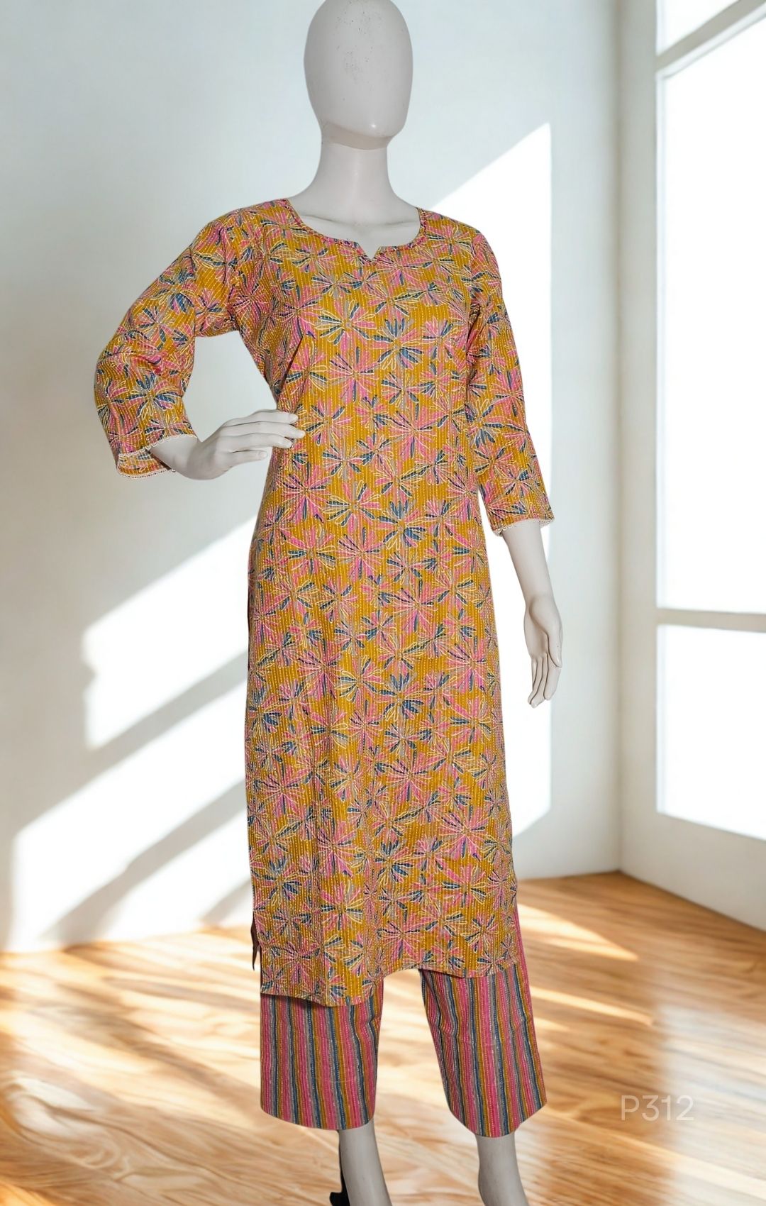 Mannequin wearing a patterned kurta with pants in a bright room.