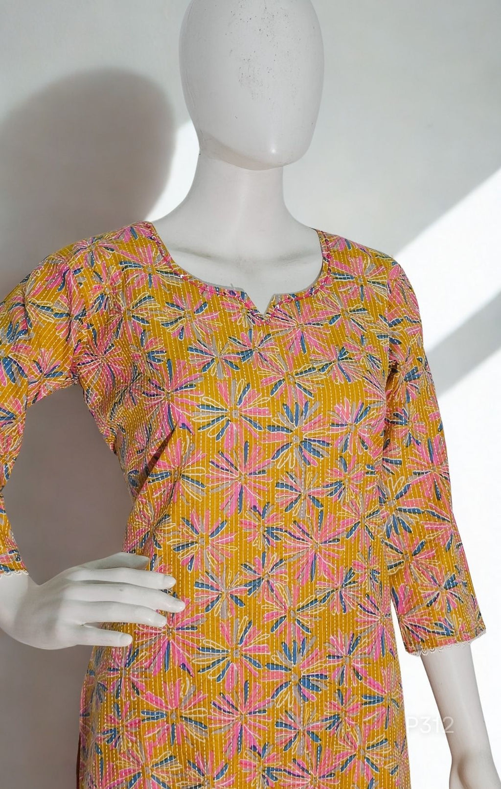 Mannequin wearing a colorful patterned dress with a white background