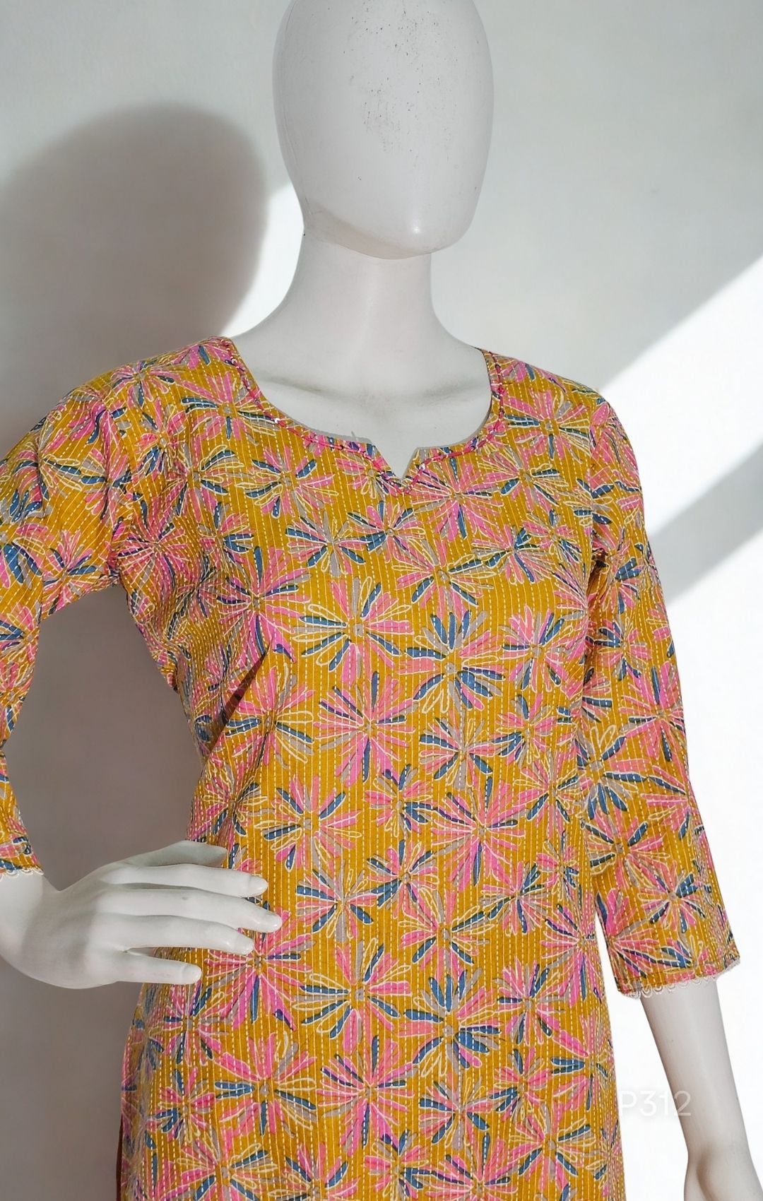Mannequin wearing a colorful patterned dress with a white background