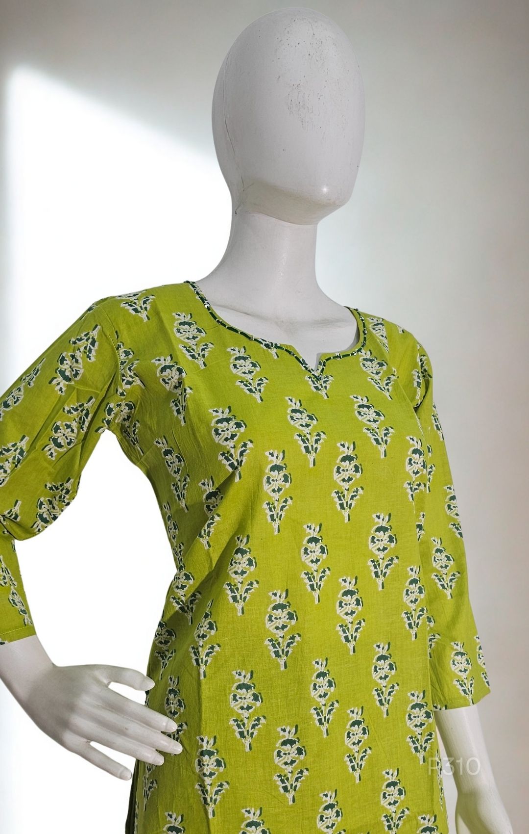 Green floral dress on a mannequin against a white background