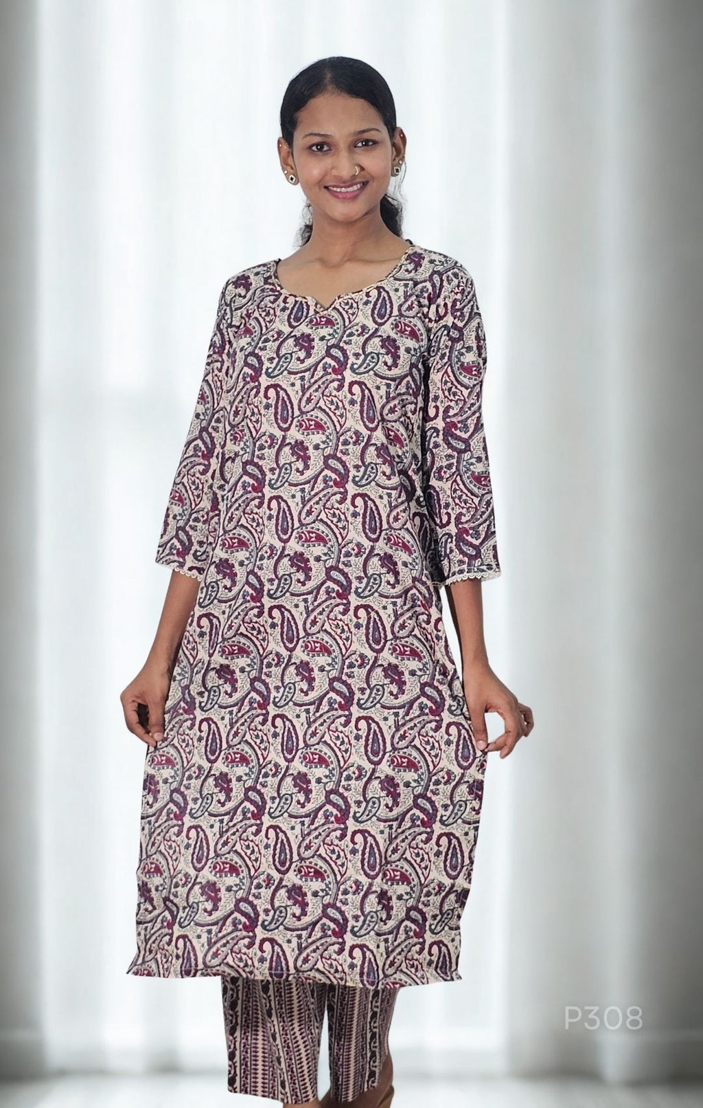 Woman wearing a patterned kurta with white curtains in the background