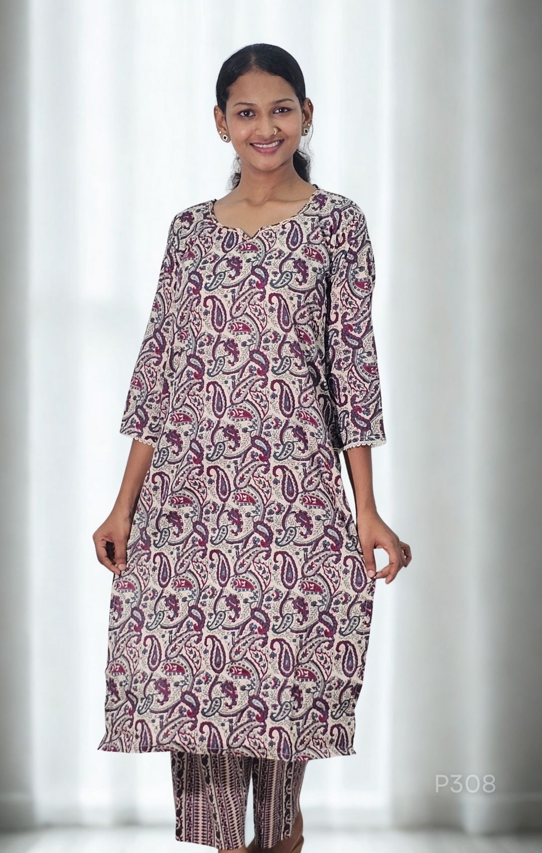 Woman wearing a patterned kurta with white curtains in the background