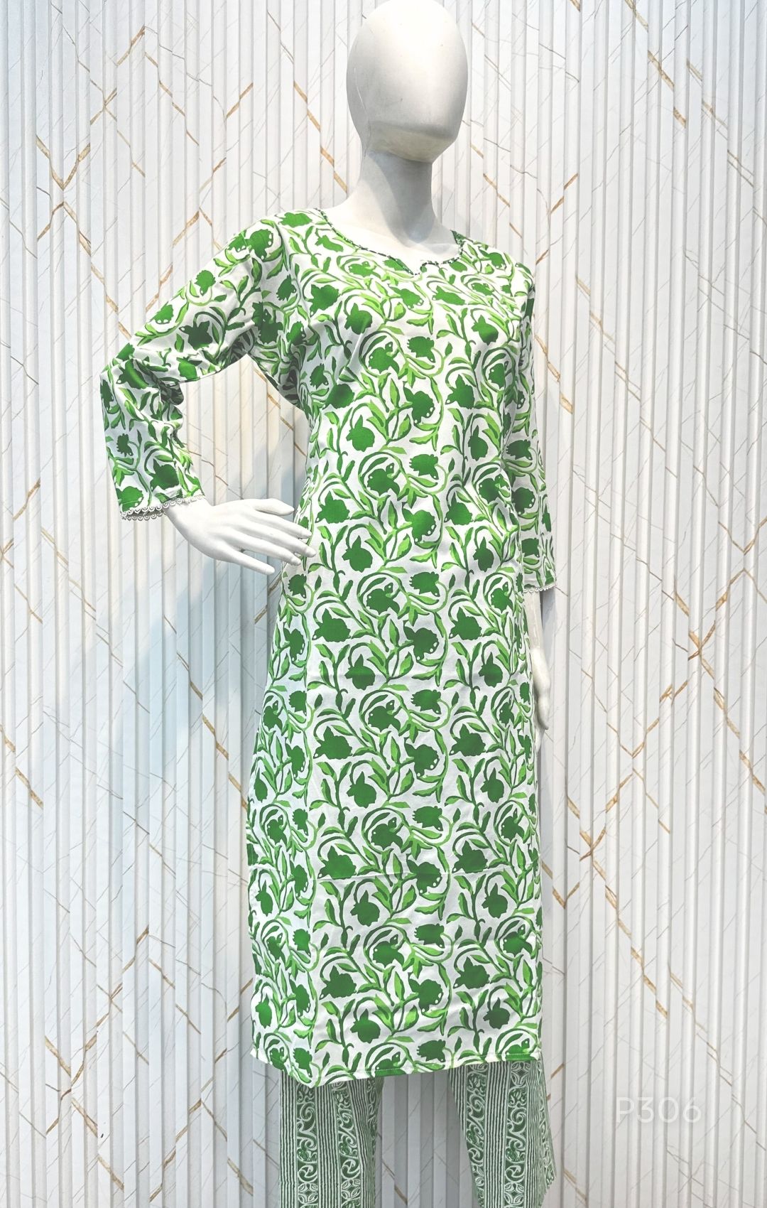 Green patterned dress on a mannequin against a white background