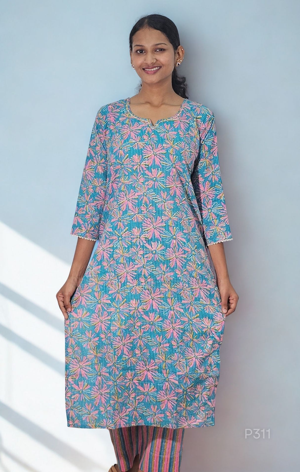 Woman wearing a floral kurta with a light blue background