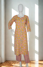 Mannequin wearing a patterned kurta with pants in a bright room.