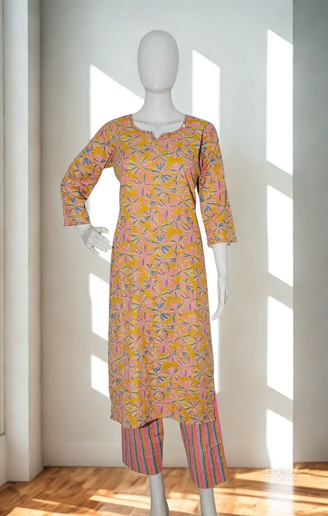 Mannequin wearing a patterned kurta with pants in a bright room.