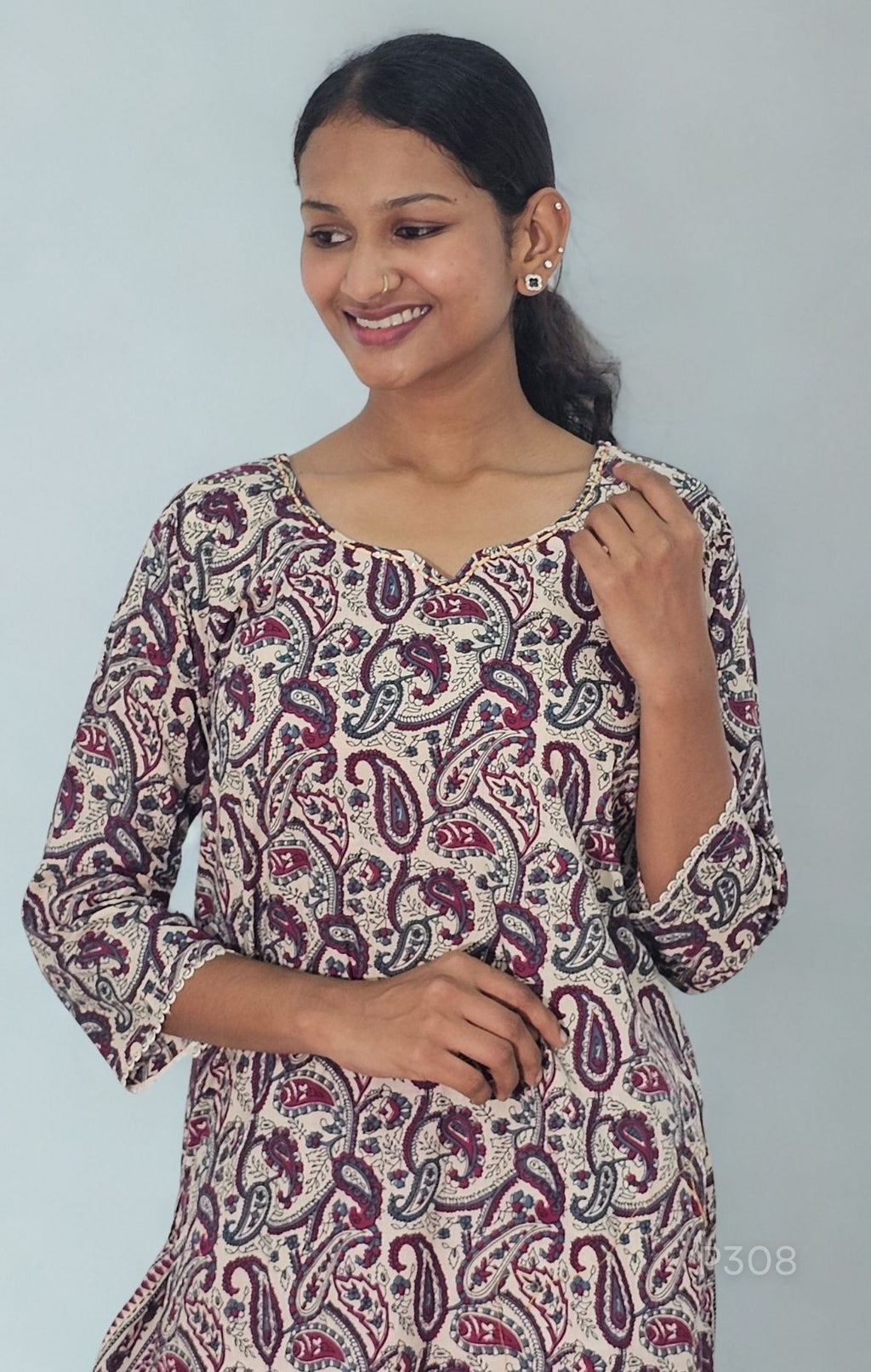 Woman wearing a patterned dress against a plain background