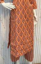 Orange patterned kurta with matching pants on a mannequin against a white background