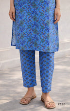 Person wearing a blue floral outfit with matching pants on a light gray background