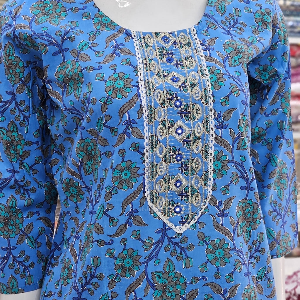 Blue floral patterned garment with intricate detailing on a mannequin.