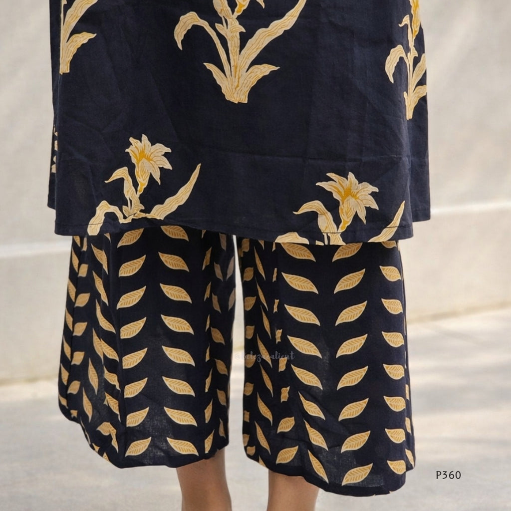 black outfit with gold floral patterns on a neutral background