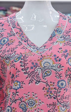 Mannequin wearing a pink floral patterned top with a blurred background