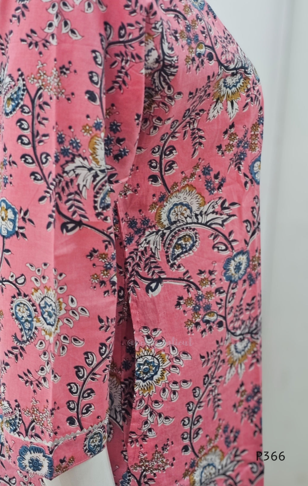 Pink fabric with floral and paisley pattern on a white background
