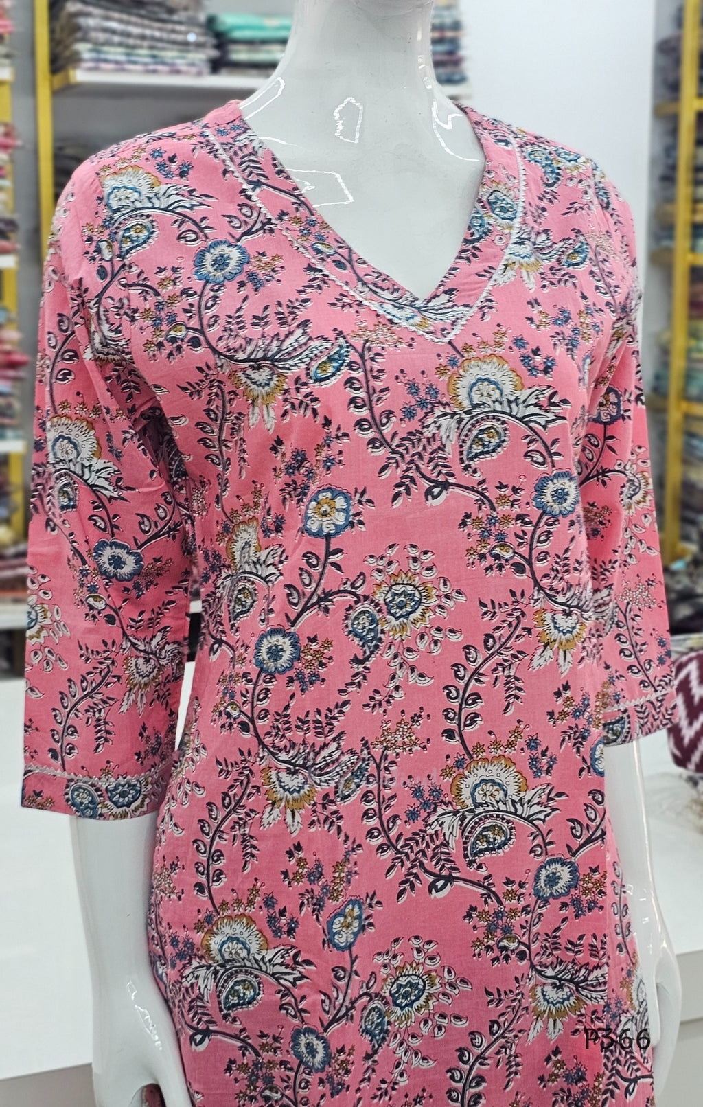 Pink floral patterned dress on a mannequin in a store setting