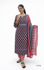 Woman wearing a navy blue and pink traditional outfit with a red dupatta on a white background