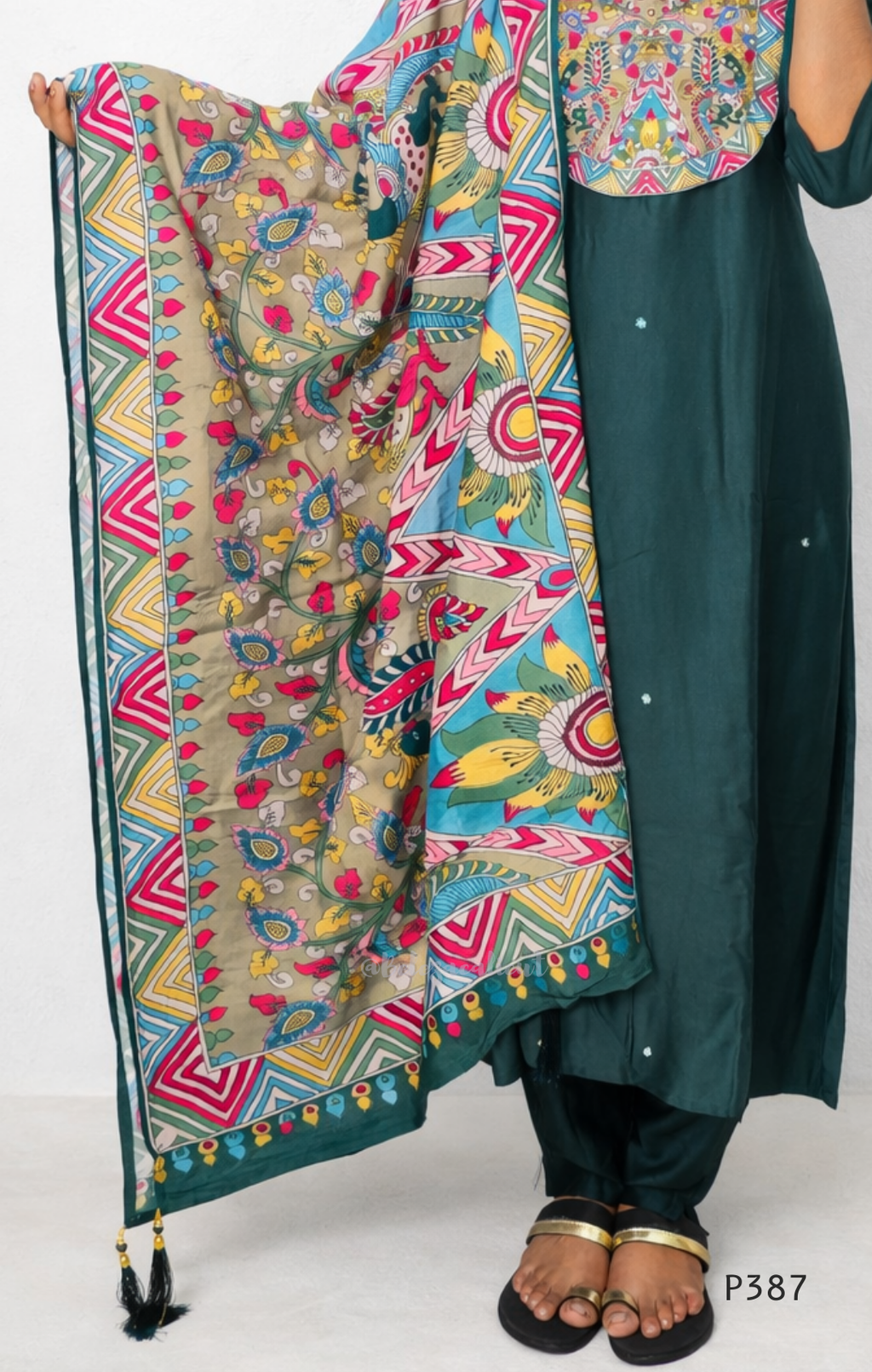 Person wearing a green kurta with a colorful patterned dupatta on a white background