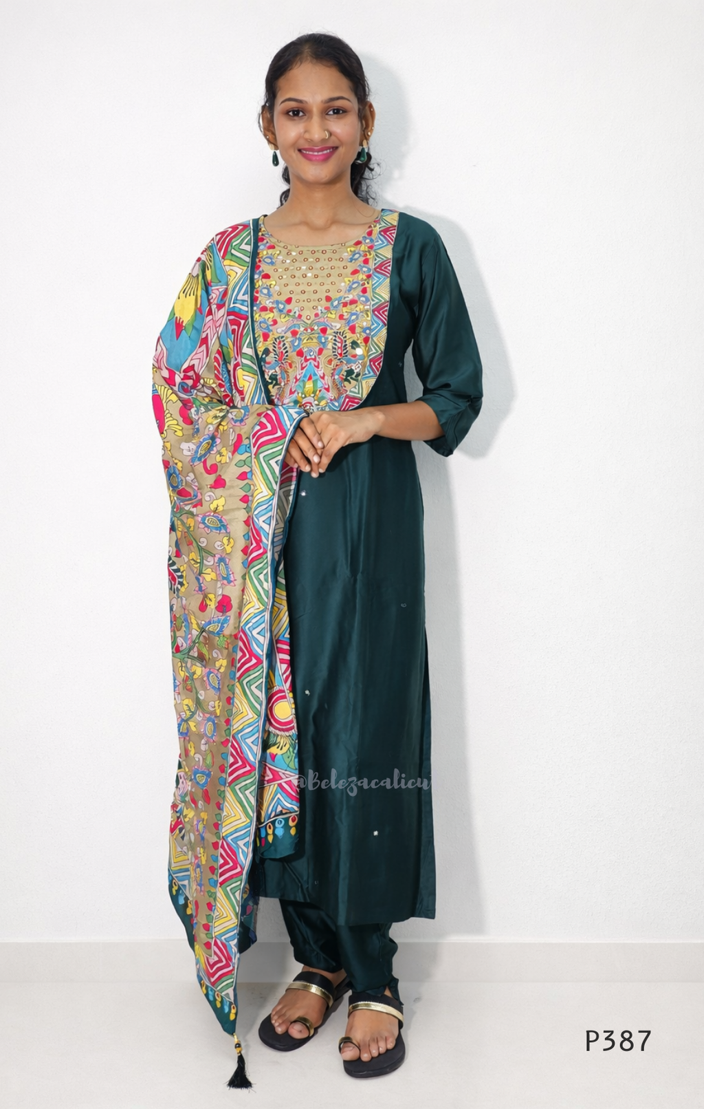 Woman wearing a dark green kurta with a colorful dupatta on a white background