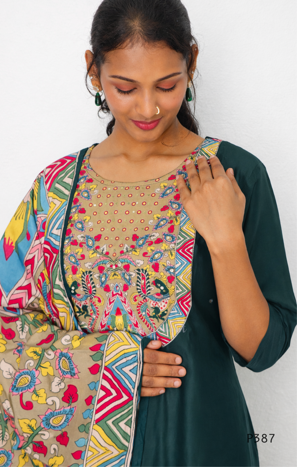 Woman wearing a colorful patterned top with a plain background