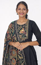 Woman wearing a black kurta with floral embroidery on a white background