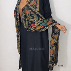 Black dress with a colorful floral scarf draped over the shoulder on a white background