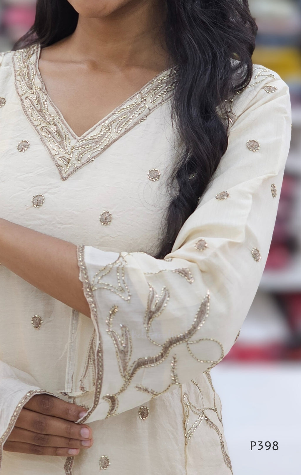 Close-up of a person wearing a white embroidered outfit with a blurred background