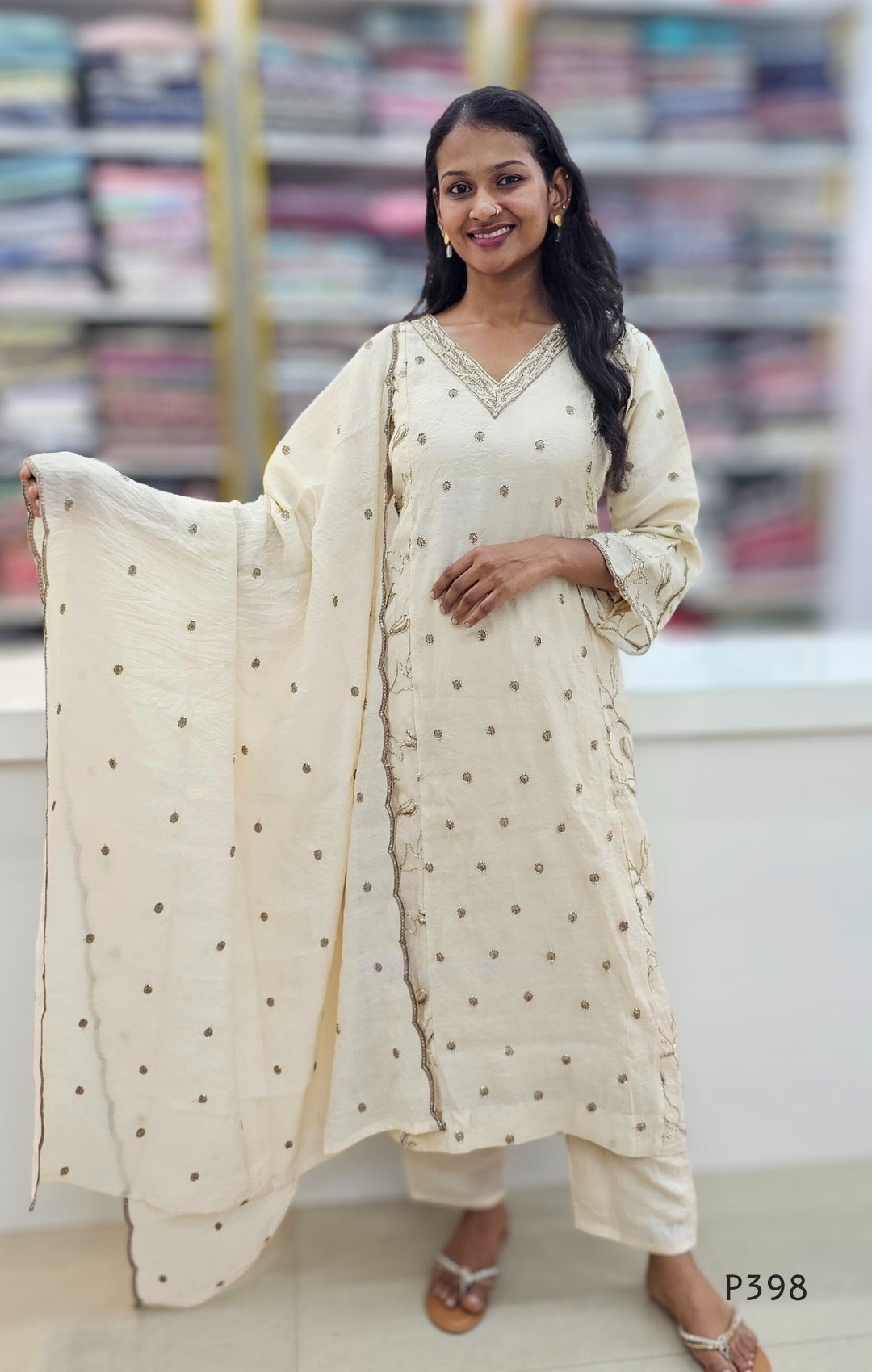 Woman wearing a traditional outfit with a white dupatta in a store setting