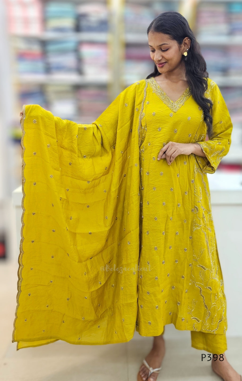 Woman wearing a yellow traditional outfit with a dupatta in a store setting