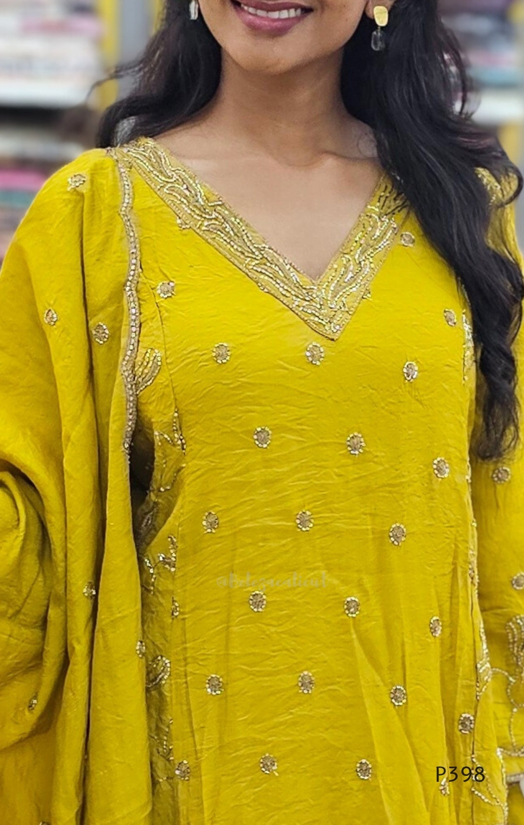 Woman wearing a yellow traditional outfit with intricate designs.