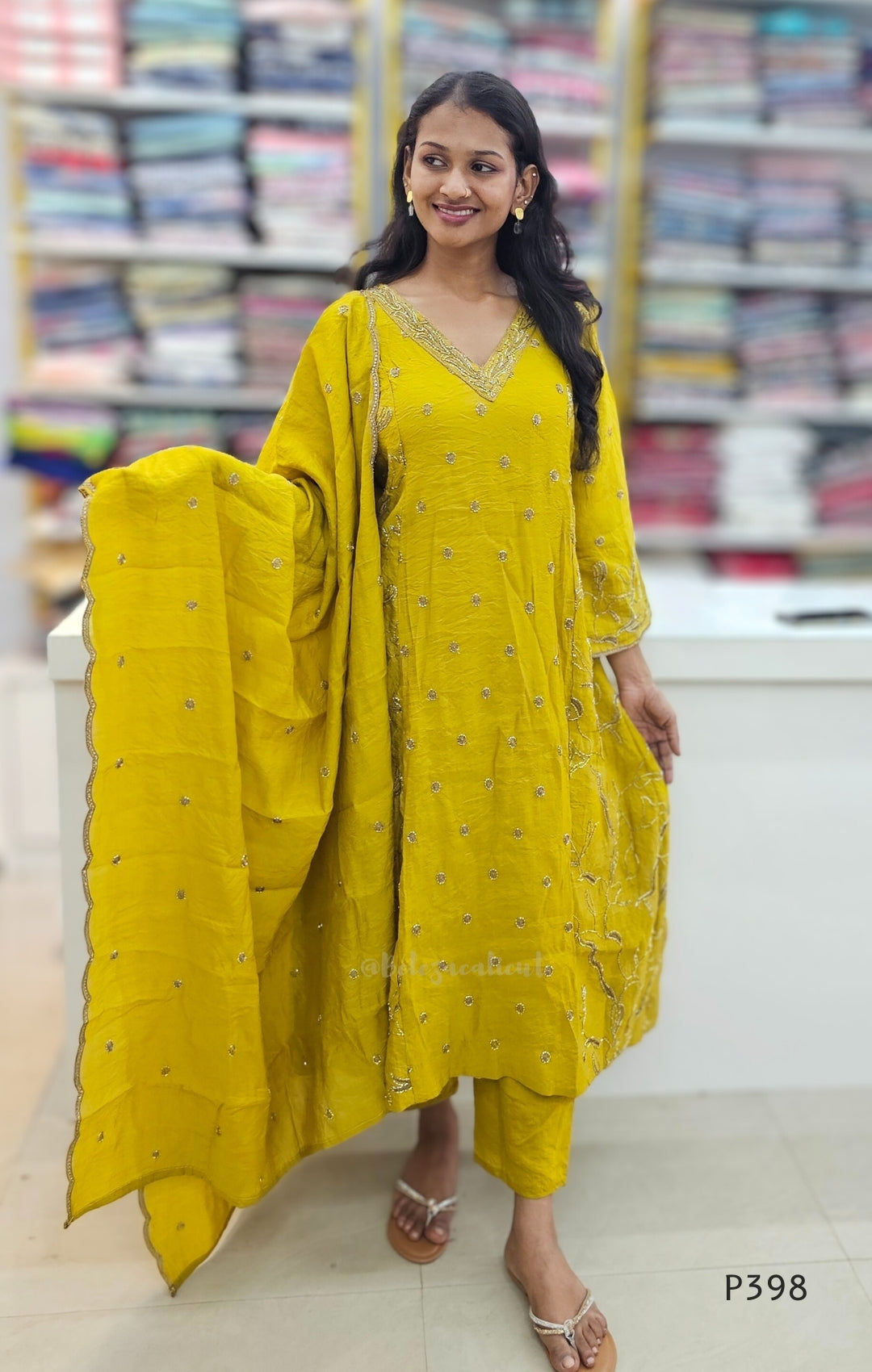 Woman wearing a yellow traditional outfit with a dupatta in a store setting