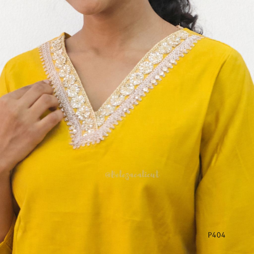Yellow kurta with white embroidery on a plain background