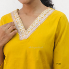 Yellow kurta with white embroidery on a plain background