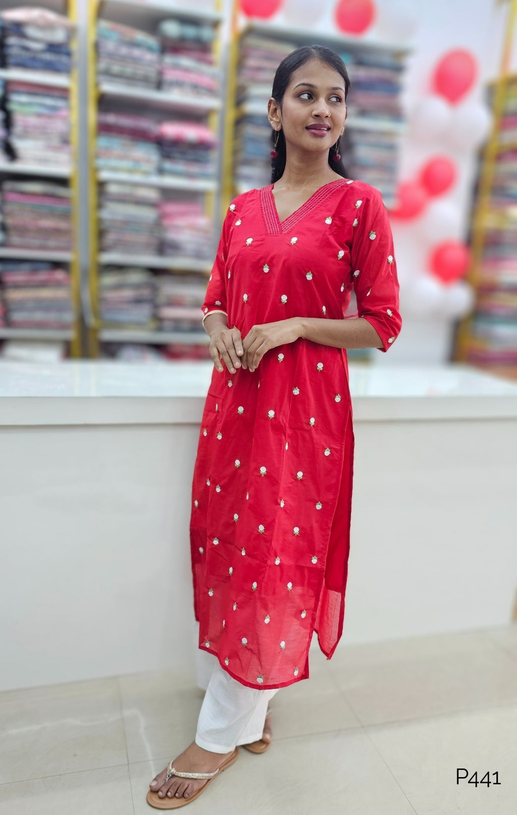 Woman wearing a red festive dress in a fabric store.