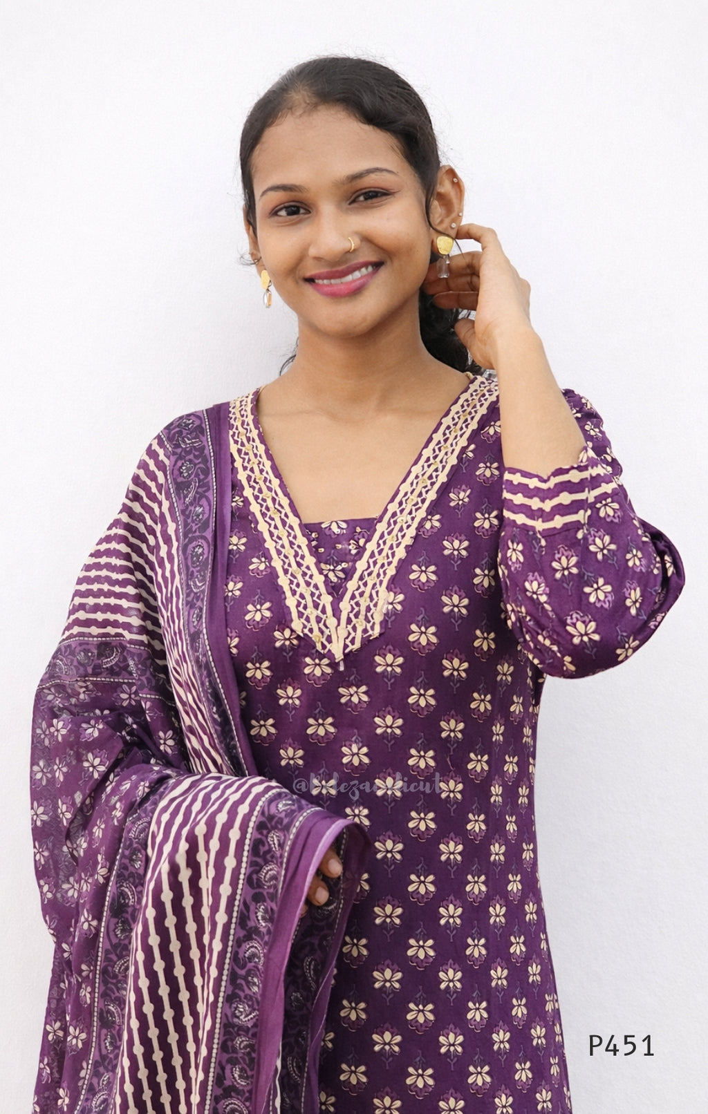 Woman wearing a purple traditional outfit with white patterns on a white background