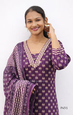Woman wearing a purple traditional outfit with white patterns on a white background