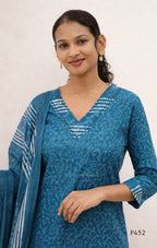 Woman wearing a blue patterned kurta with a matching dupatta on a plain background