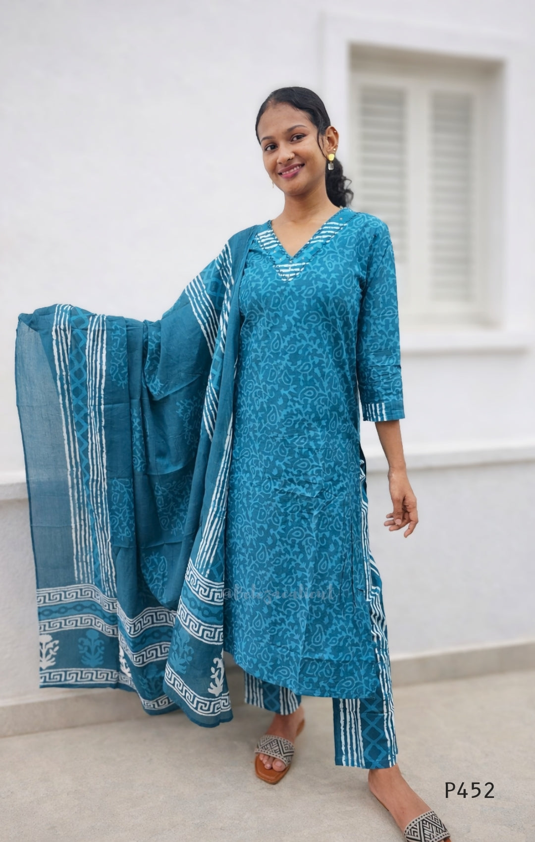 Woman wearing a blue traditional outfit with a white background