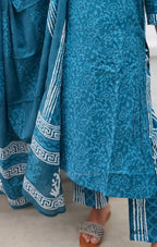 Blue patterned outfit with white details on a neutral background